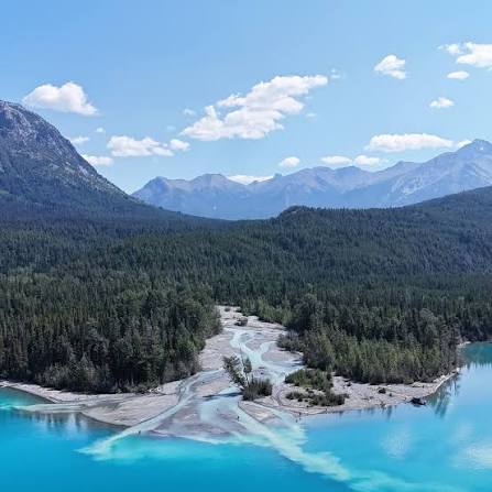 Aerial view of turquoise glacial water and forested valley