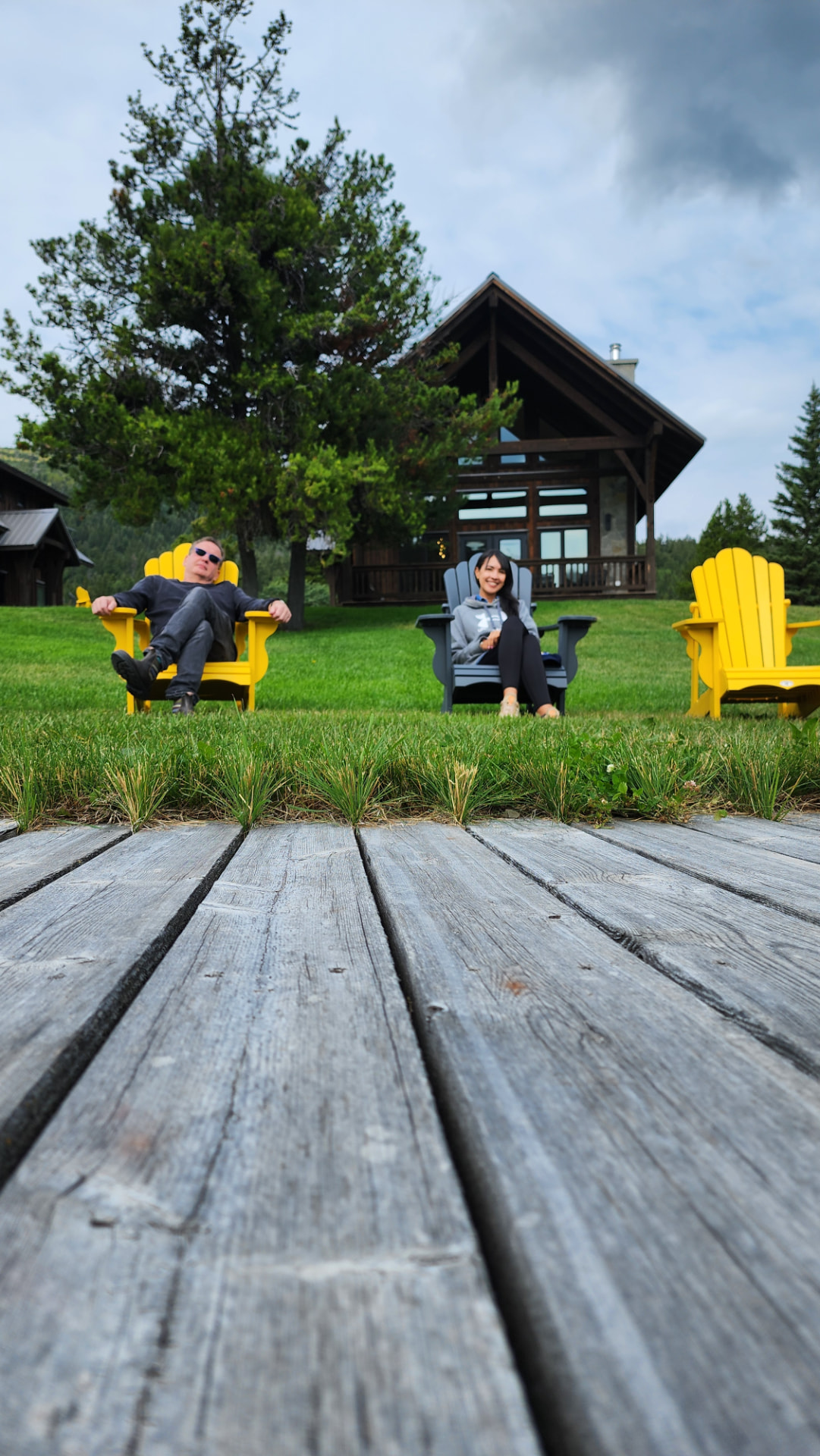 Guests resting in Adirondack chairs on the lodge lawn