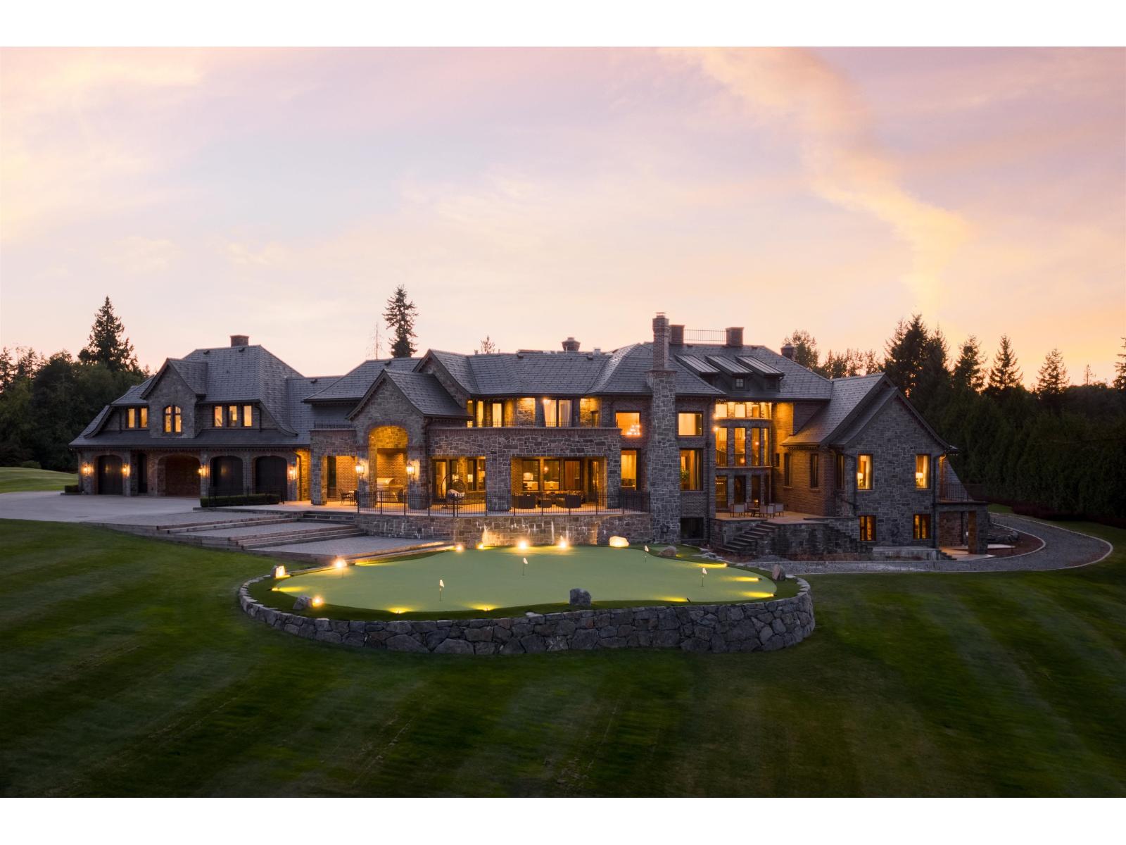The estate at sunset, lit terraces above the lawn and putting green